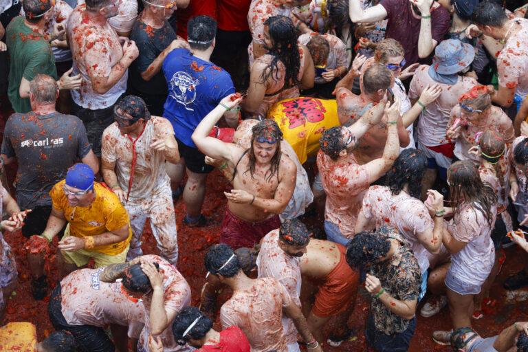 El rojo colorea el pueblo español de Buñol en una Tomatina internacional y multitudinaria