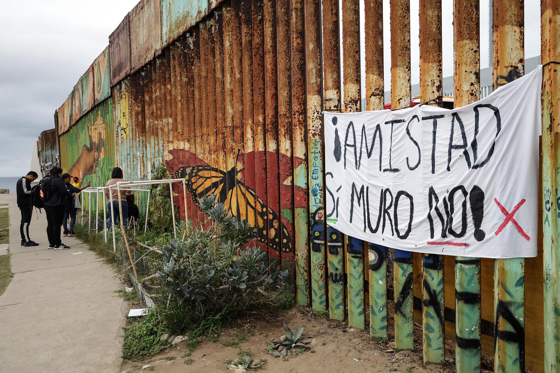 Activistas se encadenan al muro fronterizo en Tijuana en protesta por su remodelación